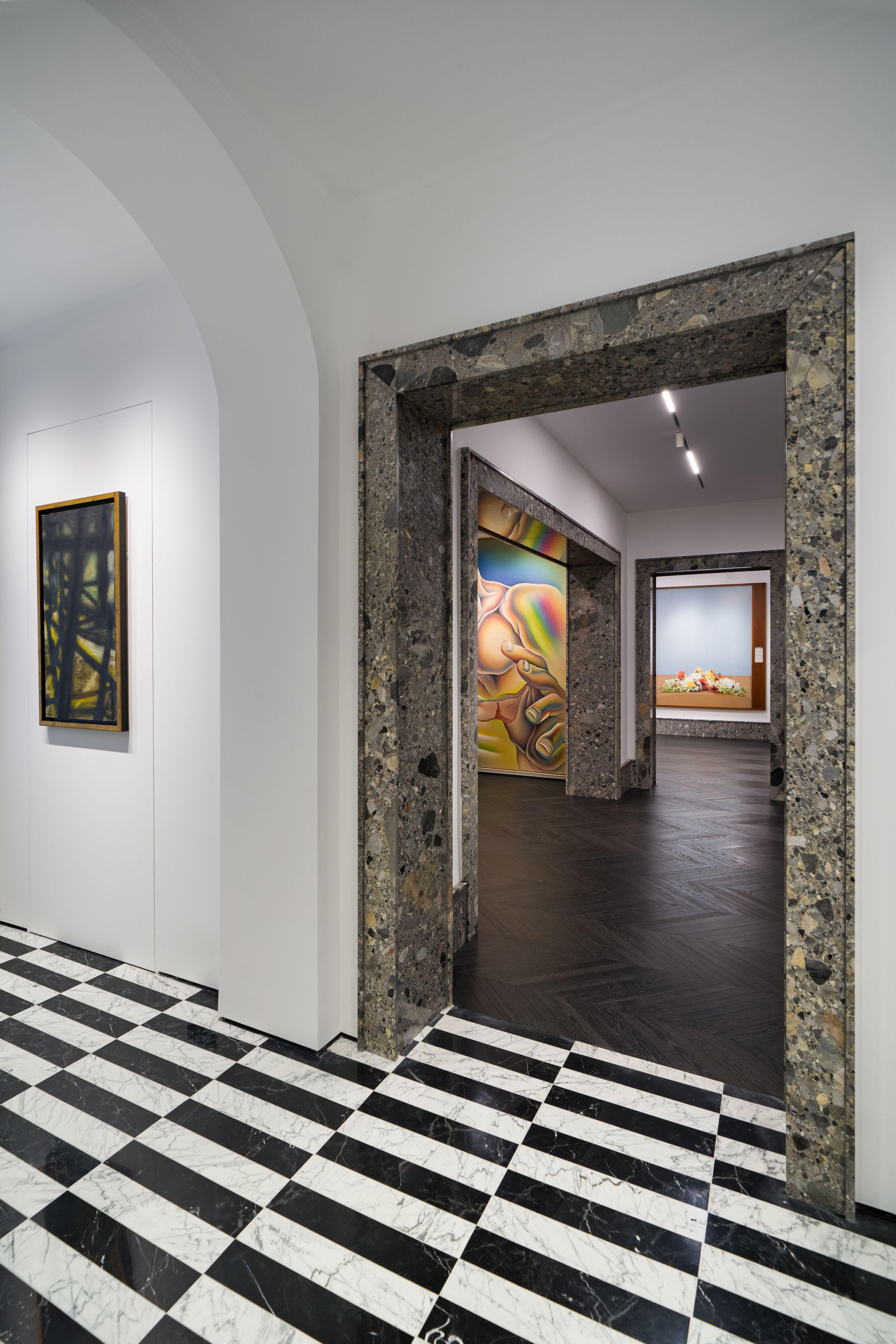 The scene captures a refined gallery interior featuring black-and-white checkered marble flooring leading into darker wood parquet rooms.